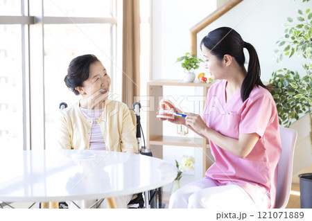 歯科衛生士から歯磨き指導を受けるシニア女性 歯科衛生士から歯磨き指導を受けるシニア女性 121071889
