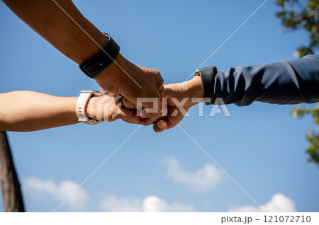 A group of sporty individuals in sportswear and smartwatches giving each other a fist bump. A group of sporty individuals in sportswear and smartwatches giving each other a fist bump. 121072710