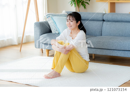 リビングでくつろぐ若い女性 リビングでくつろぐ若い女性 121073154