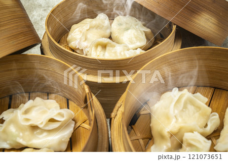 Assorted chinese dim sum dumpling on bamboo wooden basket bowl on wooden table Assorted chinese dim sum dumpling on bamboo wooden basket bowl on wooden table 121073651