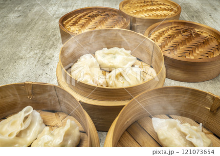Assorted chinese dim sum dumpling on bamboo wooden basket bowl on wooden table Assorted chinese dim sum dumpling on bamboo wooden basket bowl on wooden table 121073654