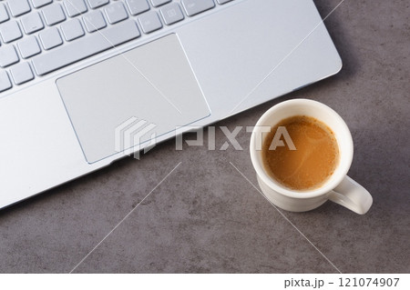 淹れたての美味しいコーヒーを飲みながら、ノートパソコンでデスクワークをしているイメージ 121074907