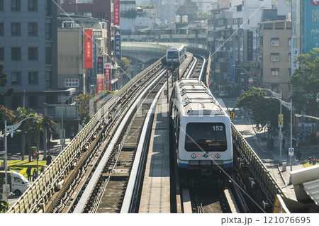 View of a Wenhu or Brown line train running on the elevated track of the Taipei Mass Rapid Transit System with the building background. 121076695
