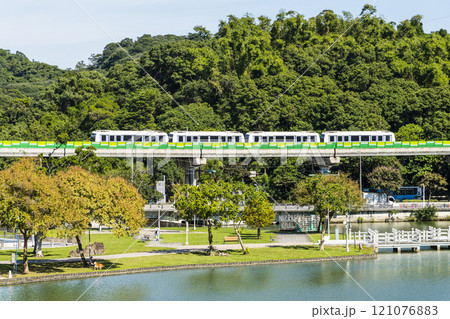 A train traveling on the Wenhu or Brown Line of the Taipei MRT, Taiwan, passes by Taipei Dahu Park. 121076883