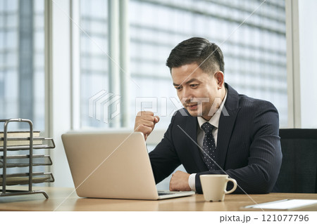 asian business man working in office using laptop computer asian business man working in office using laptop computer 121077796