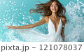 A beautiful female tourist in a light white dress walks along the beach. 121078037