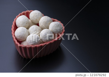 黒背景にハート型の赤い器とスノーボールクッキー 121078292