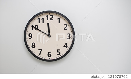 Classic Black-Edged Clock on White Background at 11.50/23.50 - Perfect for Time Management and Text Space 121078762