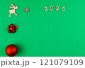 Spread on a green background chroma key, on the left there is a wooden deer with branchy antlers, a red bow and a red shiny New Year's ball, on top there is a wooden snowflake, 2025 inscription in 121079109