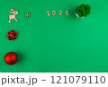 Spread on a green background chroma key on the left there is a wooden deer with branchy antlers, a red bow and a red shiny New Year's ball, on top there is a wooden snowflake, 2025 inscription in 121079110