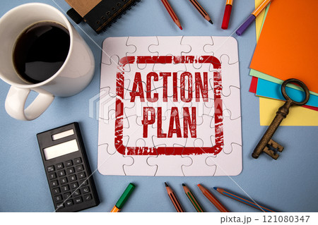 Action Plan. White puzzle and office supplies on table 121080347