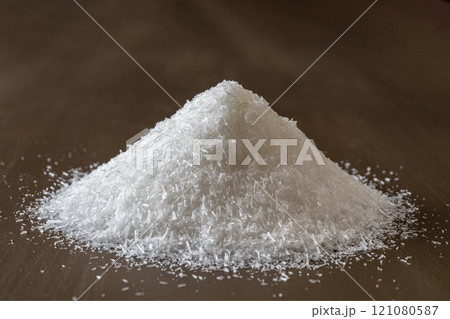 Heap of monosodium glutamate over brown background. 121080587