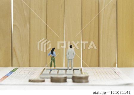 確定申告 年収の壁 お金のイメージ  確定申告書と計算機の上に立つ男女のフィギュア 121081141
