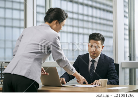 asian business manager reviewing report in office asian business manager reviewing report in office 121081266