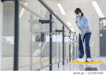 ビル清掃イメージ フロアのモップかけをするミドルの女性清掃スタッフ ビル清掃イメージ フロアのモップかけをするミドルの女性清掃スタッフ 121081489