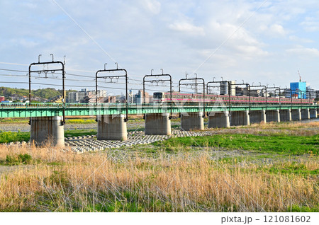 多摩川を繋ぐ幾何学的な京王線の橋梁と電車 121081602