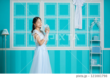 アンティークな背景で撮影をしたドレスを着た若い女性のポートレート アンティークな背景で撮影をしたドレスを着た若い女性のポートレート 121081798