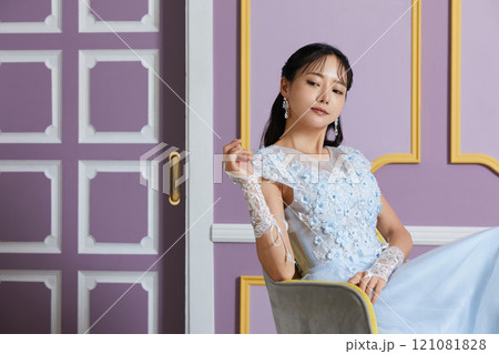 アンティークな背景で撮影をしたドレスを着た若い女性のポートレート 121081828