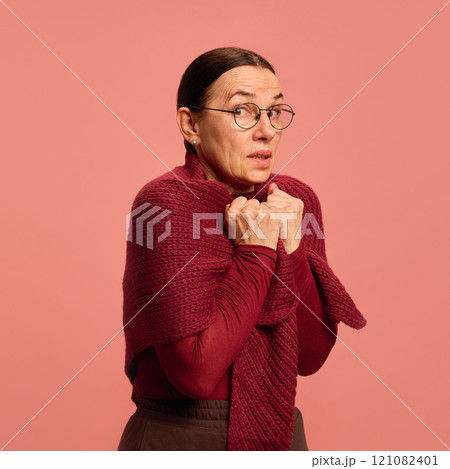 Portrait of senior woman freezing, feeling fever and sick against pastel peach background. Symptoms and treatments. Stress. 121082401