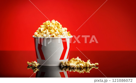 A box of fluffy popcorn against a vibrant red background A box of fluffy popcorn against a vibrant red background 121086072