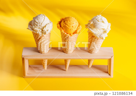 A refreshing ice cream cones set against a vibrant yellow background 121086134