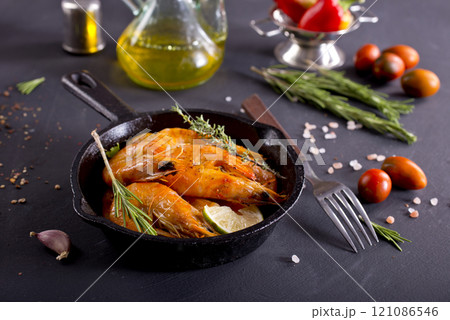 Grilled shrimps with greens and garlic in a pan Grilled shrimps with greens and garlic in a pan 121086546