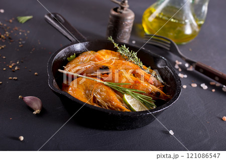 Grilled shrimps with greens and garlic in a pan Grilled shrimps with greens and garlic in a pan 121086547