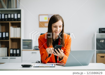 Business woman using tablet and laptop for doing math finance on an office desk, tax 121086629