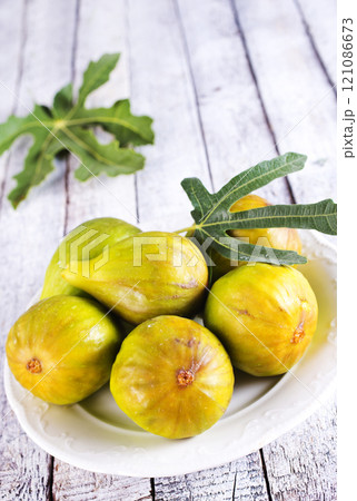 Fresh figs on plate on wooden table. 121086673