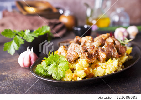 Uzbek food pilaf in iron pan. 121086683