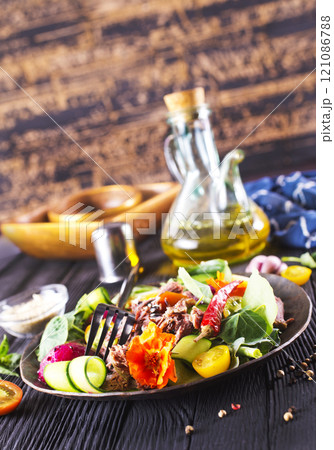 Meat steak decorated with flowers. Sliced roasted pork steak, salad. 121086788