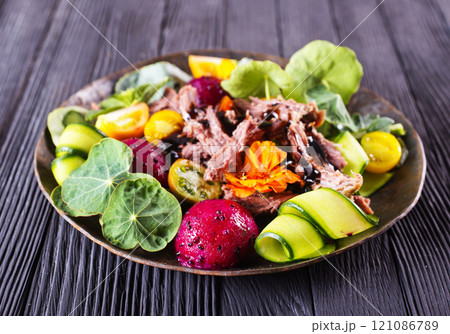 Meat steak decorated with flowers. Sliced roasted pork steak, salad. 121086789