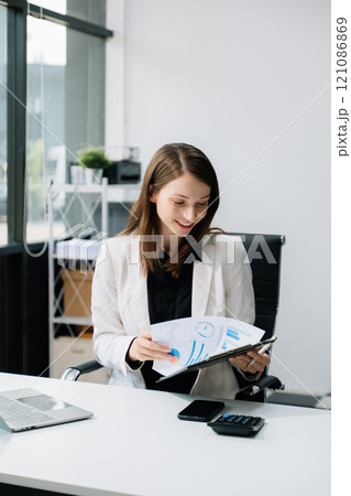 Young woman using laptop and tablet while sitting at her working place. Concentrated at work. Young woman using laptop and tablet while sitting at her working place. Concentrated at work. 121086869