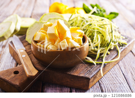 raw zucchini and patisons on board on a table 121086886