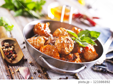 Fried cutlets from minced meat in frying pan and spices on wooden table. 121086892