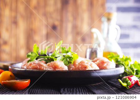 Raw meatballs on plate on a table, close up Raw meatballs on plate on a table, close up 121086904