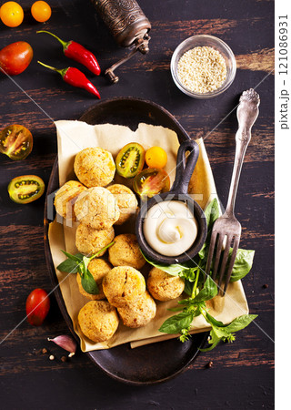 Fork with delicious falafel balls, sauce and vegetables on grunge background 121086931