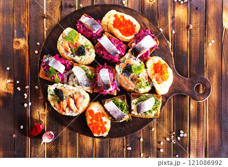 Cocktail canapes with herring, cream cheese and caviar on rye bread Cocktail canapes with herring, cream cheese and caviar on rye bread 121086992
