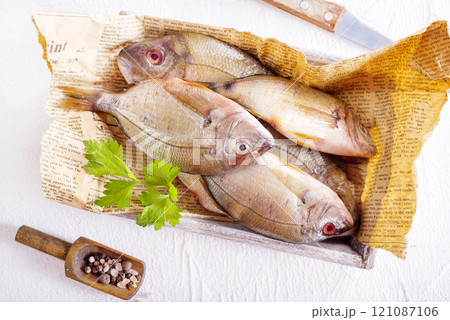 Raw fish on paper on a table Raw fish on paper on a table 121087106