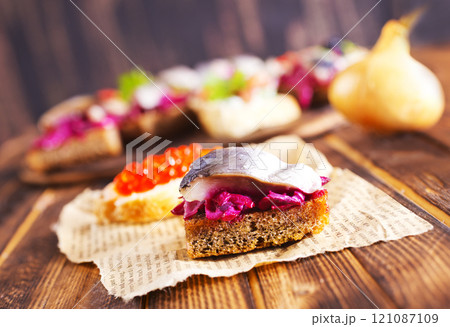 Cocktail canapes with smoked salmon, herring, cream cheese and caviar on rye bread - gourmet party food. 121087109