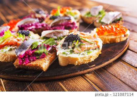 Cocktail canapes with smoked salmon, herring, cream cheese and caviar on rye bread - gourmet party food. Cocktail canapes with smoked salmon, herring, cream cheese and caviar on rye bread - gourmet party food. 121087114