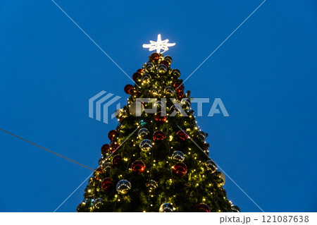 Street, Christmas tree in the city center in the evening. New Year's background Street, Christmas tree in the city center in the evening. New Year's background 121087638