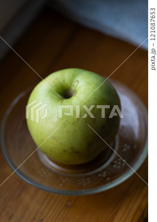 A clean green apple on a saucer 121087653