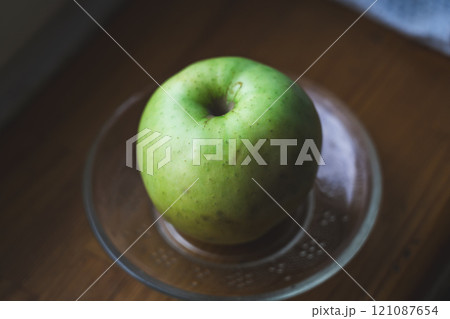 A clean green apple on a saucer 121087654