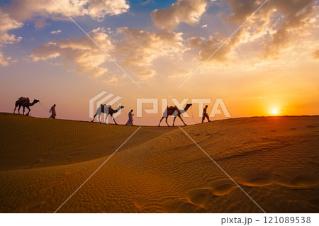 Indian cameleers camel drivers camel silhouettes in dunes on sunset. Jaisalmer, Rajasthan, India 121089538