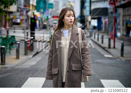 散歩するコートを着たロングヘアーの若い女性 散歩するコートを着たロングヘアーの若い女性 121090522
