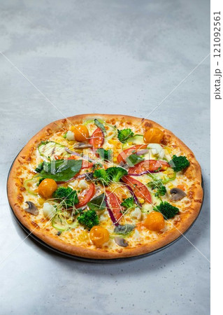 Delicious vegetarian pizza lying on gray table background Delicious vegetarian pizza lying on gray table background 121092561