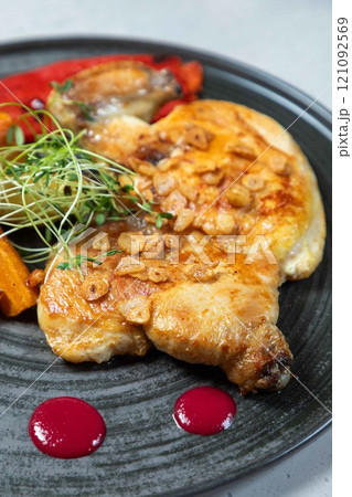 Delicious roasted chicken breast with garlic and herbs on plate Delicious roasted chicken breast with garlic and herbs on plate 121092569