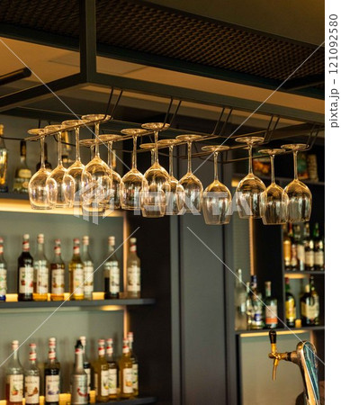 Wine glasses hanging over bar counter in restaurant 121092580