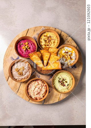 Colorful selection of dips served with pita bread on wooden board Colorful selection of dips served with pita bread on wooden board 121092603